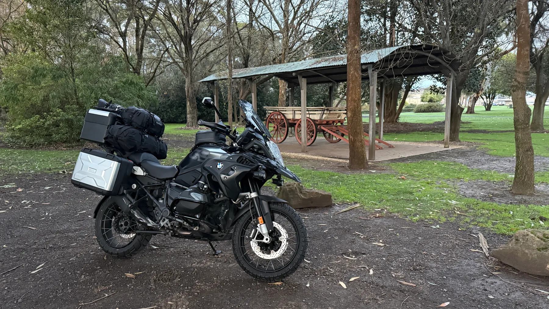 Loaded BMW R1250GS parked beside a historic wagon during the founder's ride