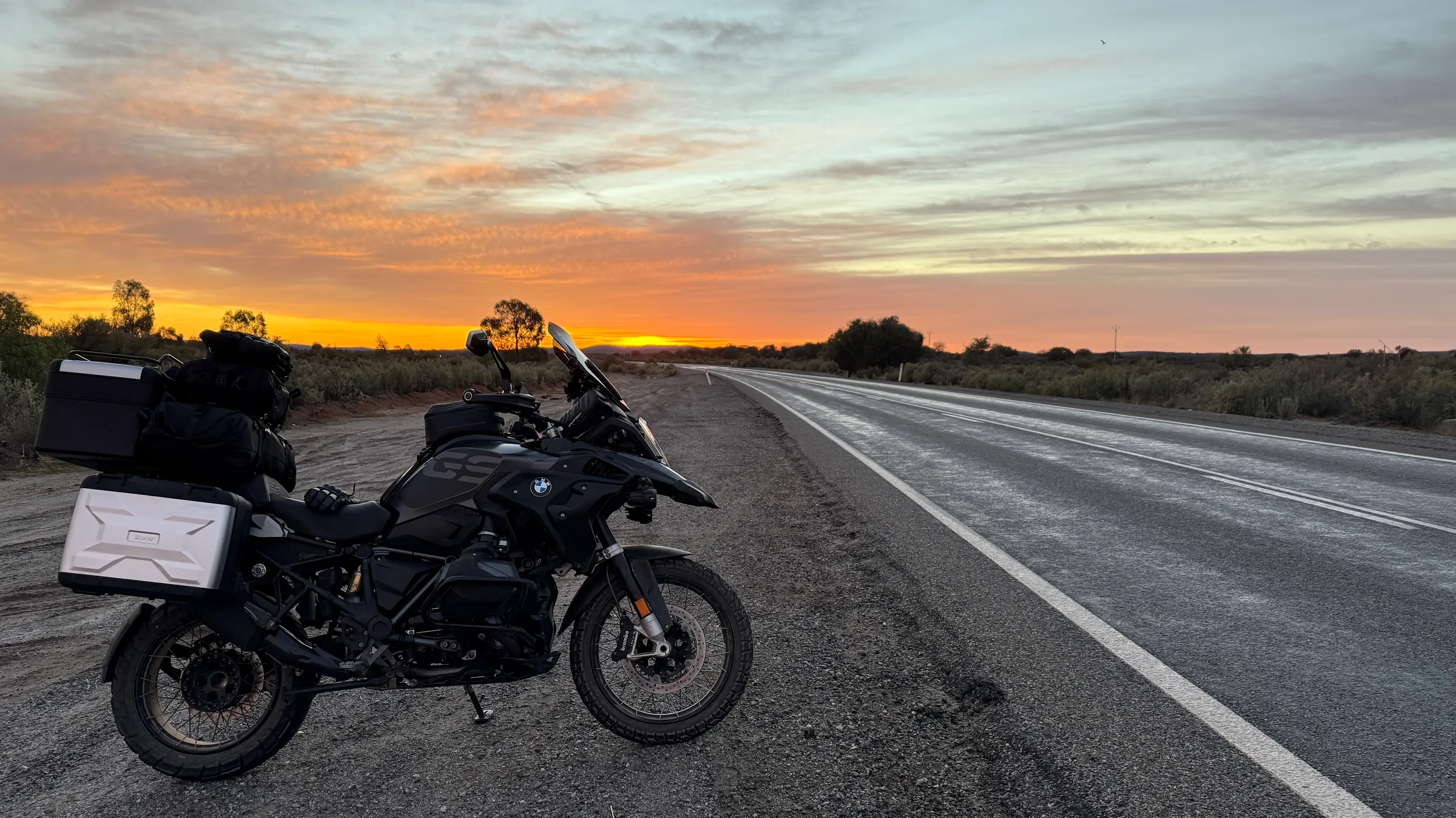 BMW R1250GS at sunset on an open road